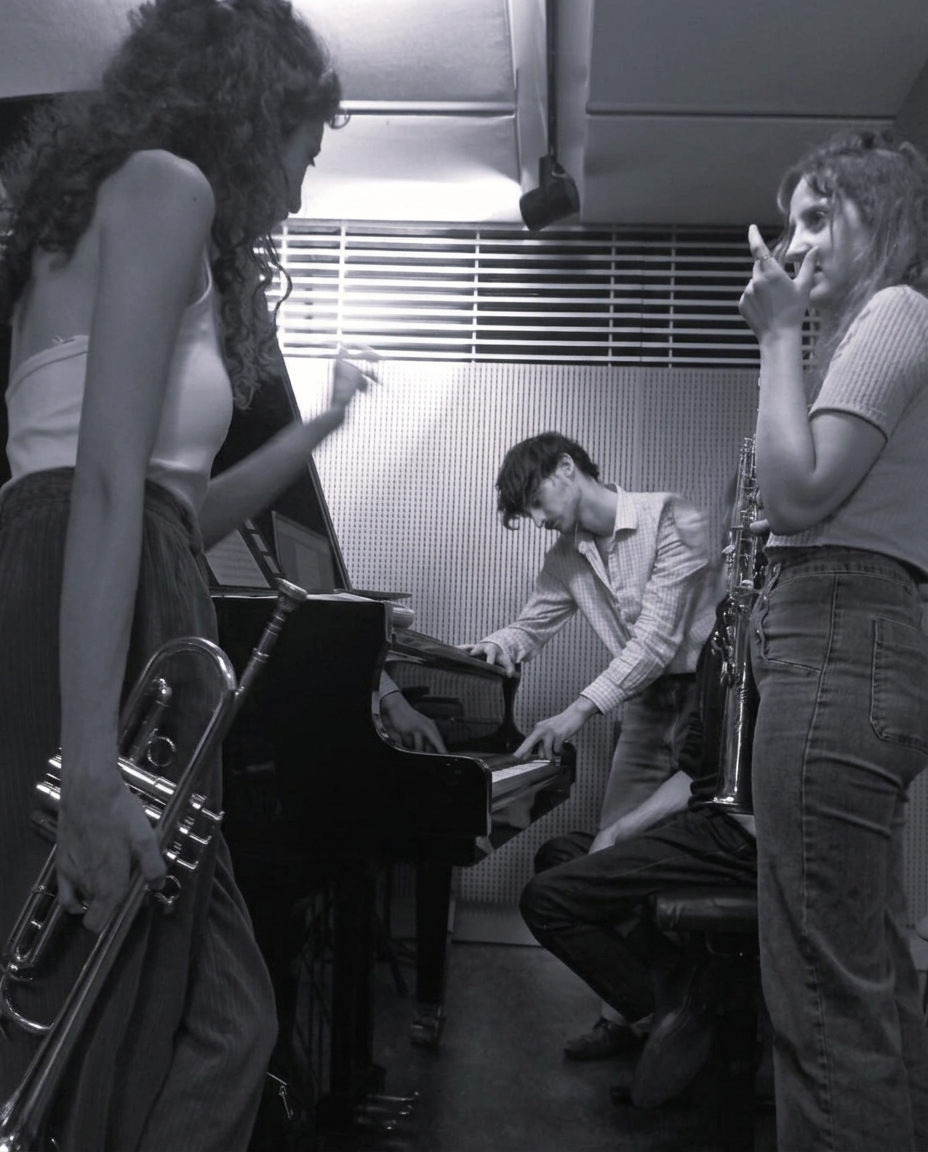 Paul Gonzalez au piano en répétition avec des musiciennes, photo en noir et blanc